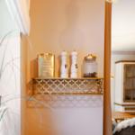 Goldschale mit Salz- und Pfeffermühle, Zuckerdose und Kaffeefilter auf Wandregal.