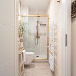 Badezimmer mit Dusche, Toilette und Handtuchheizung.