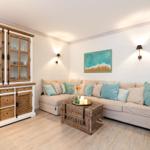 Ein Wohnzimmer mit Sofa, Kissen, Kiste und Schrank an der Wand.