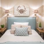 Schlafzimmer mit Bett, zwei Nachttischen und Wanddekoration.