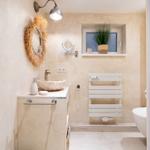 Bad mit Waschbecken, Spiegel, Heizkörper und Fenster