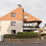 Modernes Haus mit Balkon und Steinmauer. Wohnhaus in ruhiger Wohngegend.