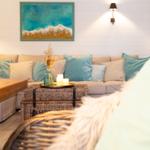 Ein Wohnzimmer mit Sofa, Kissen und einem Korbtablett mit Kerzen.