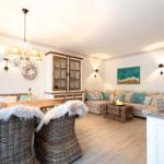 Wohn- und Essbereich mit Sofa, Esstisch und Kücheninsel.