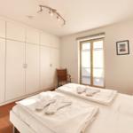 Schlafzimmer mit Doppelbett, Kleiderschrank und Fenster mit Jalousie.