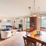 Wohn- und Essbereich mit Holztisch, Sofa und Terrassentür.