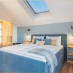 Schlafzimmer mit Dachfenster, Bett und Holzmöbel.