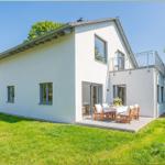 Moderne Villa mit Terrasse und Garten. Tisch mit Stühlen im Freien.