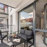 Terrasse mit Sitzgruppe und Tisch. Durchgehende Glaswände führen ins Innere.