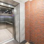 Aufnahme des Aufzugs mit Edelstahl und rotem Ziegelwand