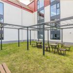 Hinterhof mit Pavillon, Tischen und Bänken auf Rasenfläche