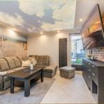 Wohnzimmer mit Sofa, Couchtisch und Fernseher an Backsteinwand.