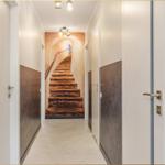 Flur mit Treppe und Türen. Wandverkleidung und Herringbone-Boden.