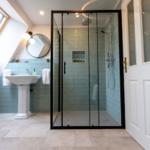 Dusche mit Glaswand, Waschbecken und Dachfenster in einem Badezimmer