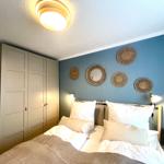 Schlafzimmer mit Bett, Kleiderschrank und Wanddekoration.