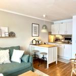 Wohnzimmer mit Sofa, Küchenbereich und Esstisch.