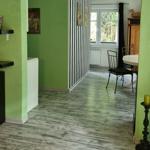 Green walls, gray floor, dining area with table and chairs, window with view of garden.