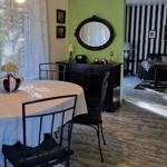 Dining area with table and chairs. Living room with black-and-white striped wall.