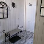 Entrance area with bench, wall decor, and door.