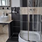 Bathroom with shower, sink, and mirror. Wall and floor tiles.