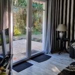 A room with black-and-white striped wall, sliding door, and TV.