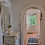 Entrance area with mirror, cabinet, and arch to the door