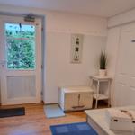 Entrance area with door, wooden floor, and nautical decor on walls.
