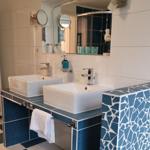 Two sinks with blue-white mosaic and mirrors