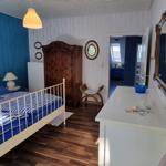 Bedroom with bed, wardrobe, and mirror. View into bathroom with shower.