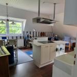 Kitchen with island, dining table, and living area with sofa and window.