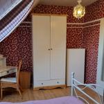 Bedroom with sloped ceiling, wardrobe, desk, and bed