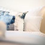 Bettkopfteil mit Kissen und Bettwäsche