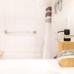 Bad mit Waschbecken, Dusche und Handtuchhalter.