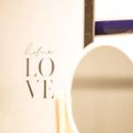 Wand mit Aufschrift home LOVE, runder Spiegel und Pflanze