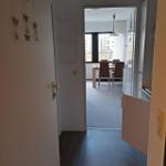 Flur mit Blick in Essbereich und Küche. Holzboden und Fenster mit Blick.