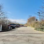 Eingangsbereich mit Parkplatz und Stellplatz für Autos unter blauem Himmel.