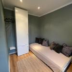 Schlafzimmer mit Bett, Kleiderschrank und Teppichboden.