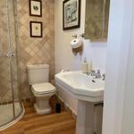 Badezimmer mit Dusche, Toilette und Waschbecken auf Sockel