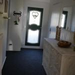 Entrance area with door, dresser, and mirror on the wall.