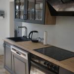 Kitchen with range hood, sink, cooktop, and dishwasher.