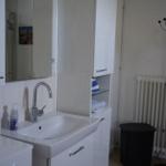 Bathroom with sink, mirror, and white cabinets