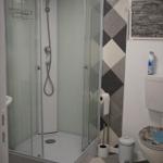 Bathroom with shower, toilet, and patterned floor