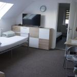 Bedroom with skylight, TV, and cabinet. Door leads to another room.