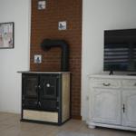 Stove against brick wall, TV on white cabinet