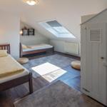 Zimmer mit zwei Betten, Dachfenster und Kleiderschrank.