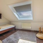 Schlafzimmer mit Dachschrägen, Dachfenster und Holzboden