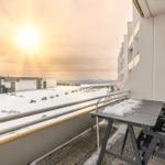 Balkon mit Tisch und Stühlen, Schnee bedeckt den Boden und die Landschaft.