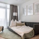 Schlafzimmer mit Sofa-Bett, Wandbildern und großem Fenster mit Blick.