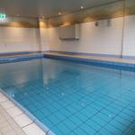 Innenpool mit blauen Fliesen und Metalltreppe