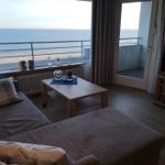 Wohnzimmer mit Sofa, Couchtisch und TV. Blick aufs Meer vom Balkon.